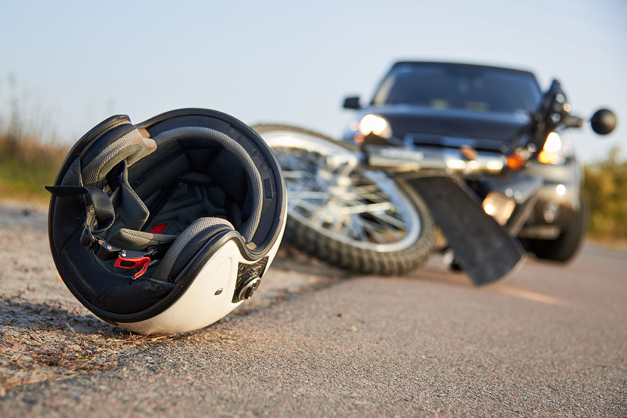 Photo of car, helmet and motorcycle on road, the concept of road accidents.